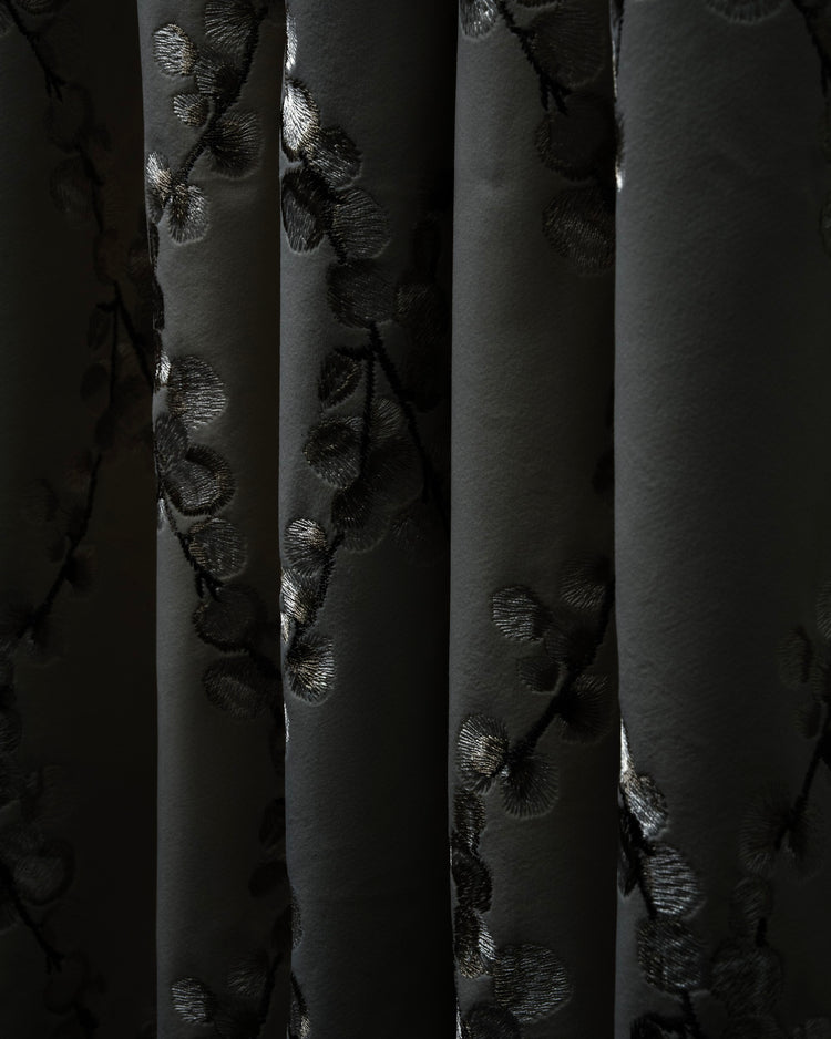 Close-up of Flora velvet custom curtain in dark grey with shimmering embroidered floral pattern detailing on elegant folds.