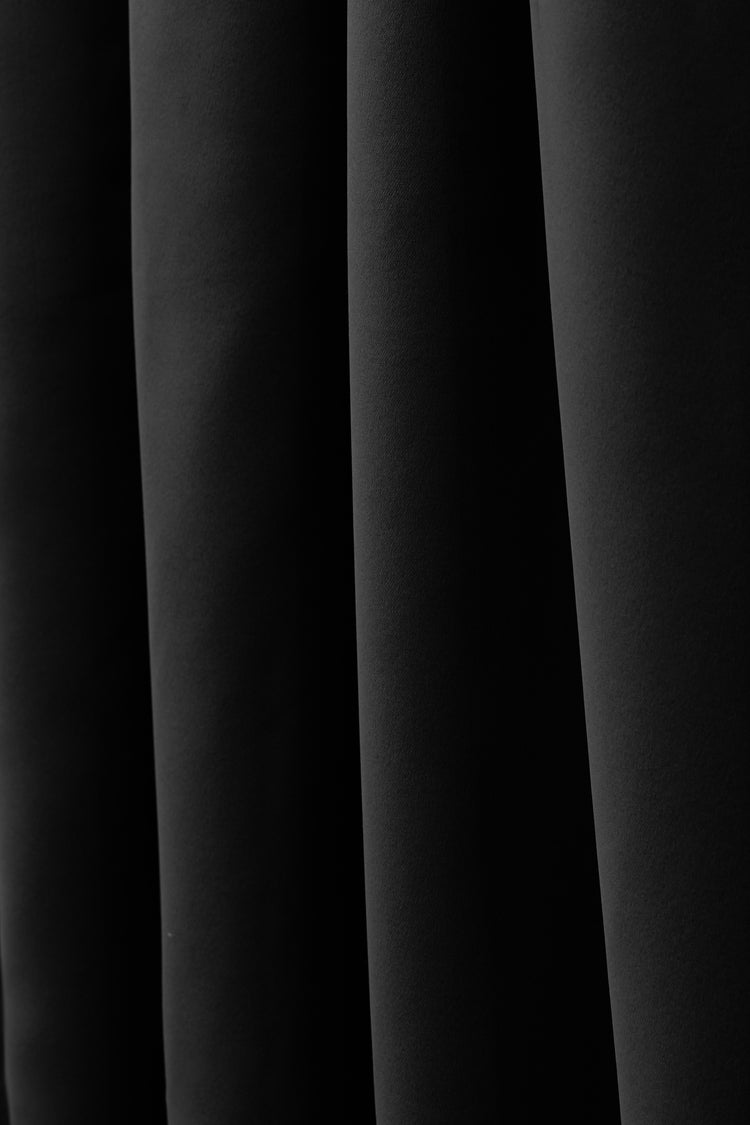 Custom Frisian flame retardant curtain fabric in deep black, showcasing rich texture and elegant folds for superior light control & privacy.
