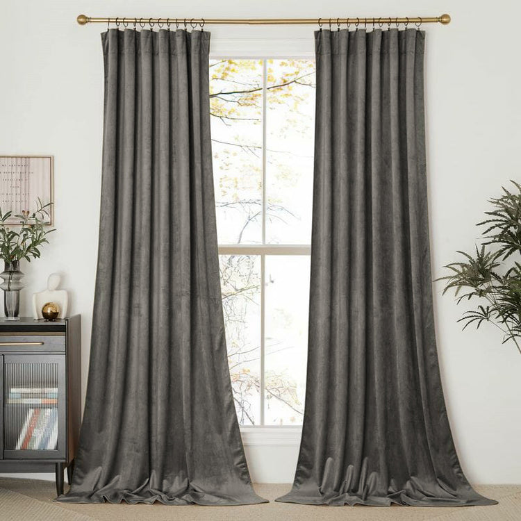 Tailored charcoal velvet drapery panels on a gold rod, offering sophisticated privacy & light control for custom window treatments.