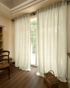 Elegant Helena pure linen custom window treatments, made-to-measure with a relaxed drape, framing a sunlit window and dark floors.