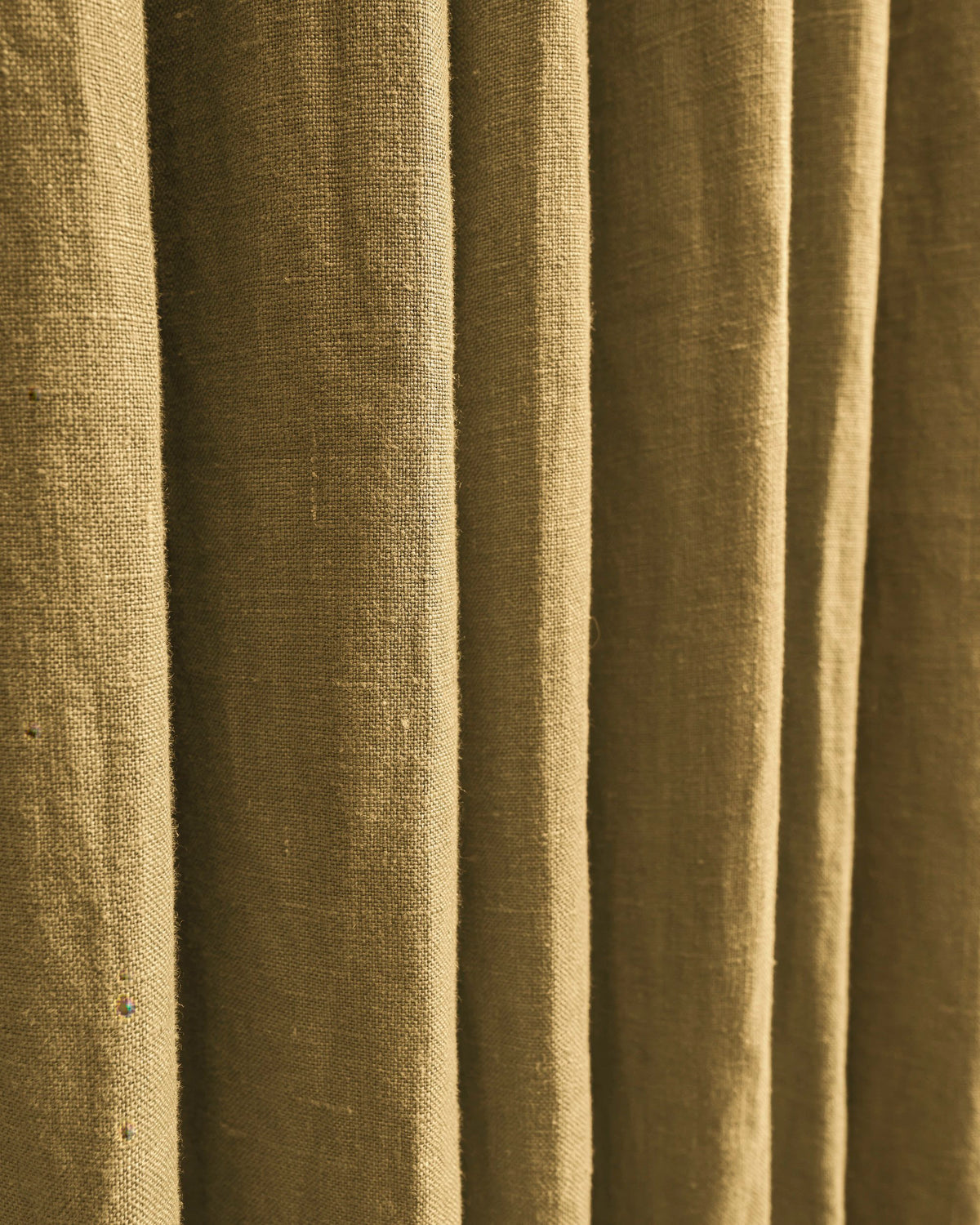 Close-up of TheHues Helena 100% pure linen custom drapery fabric, revealing natural texture and soft, elegant pleats.