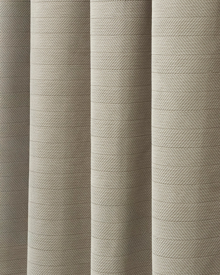 Detailed view of beige herringbone chenille fabric, highlighting its plush texture for custom 100% blackout curtains.