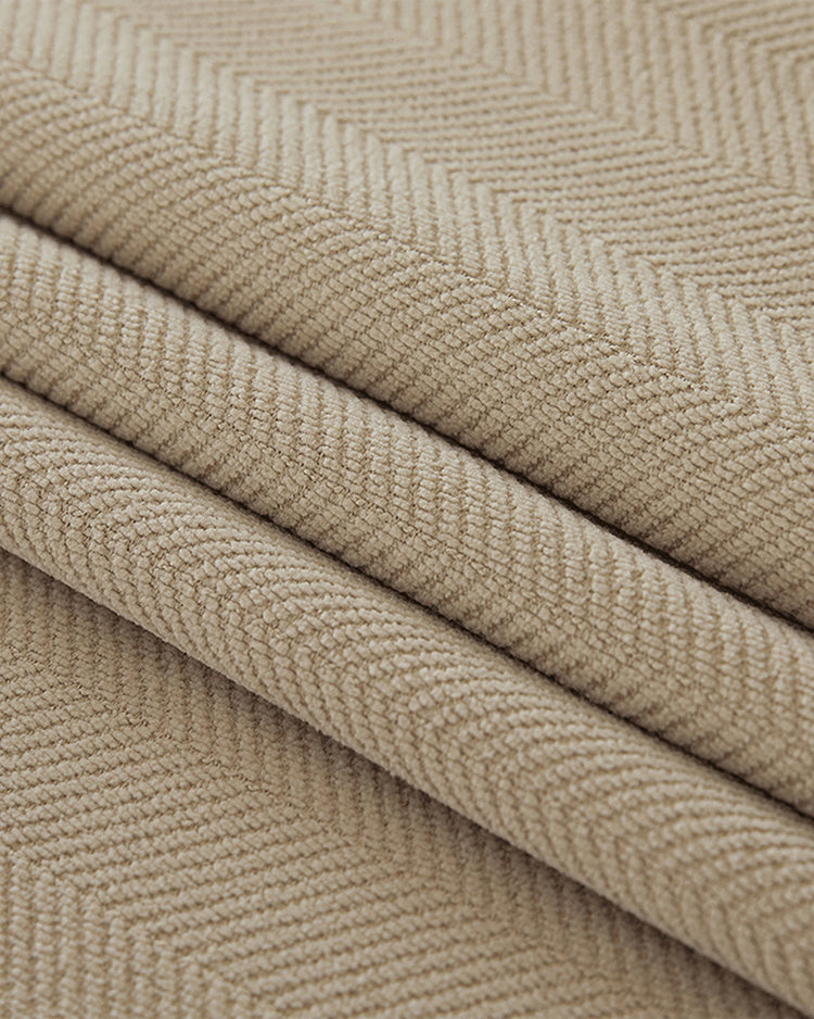 Close-up of folded beige herringbone chenille fabric, highlighting its texture for soundproof thermal blackout drapes.
