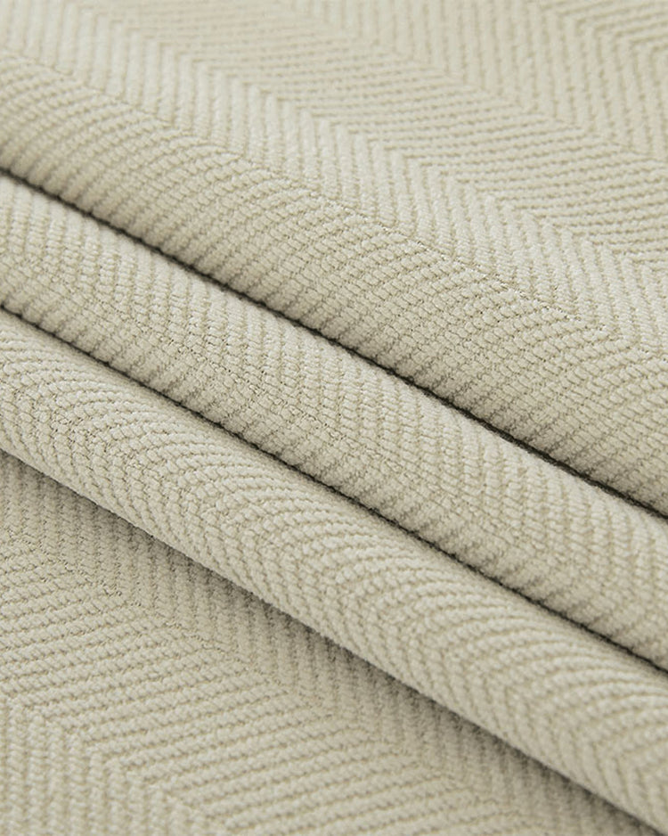 Soft beige herringbone chenille fabric swatch, folded to display its plush texture for custom soundproof thermal blackout drapes.