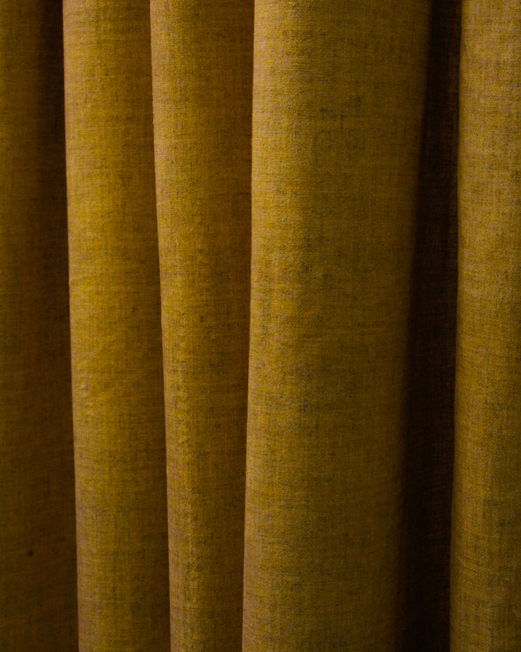 Close-up: Jazlynn custom heavyweight linen curtain fabric, rich mustard yellow with subtle texture & deep folds for elegant window treatments.