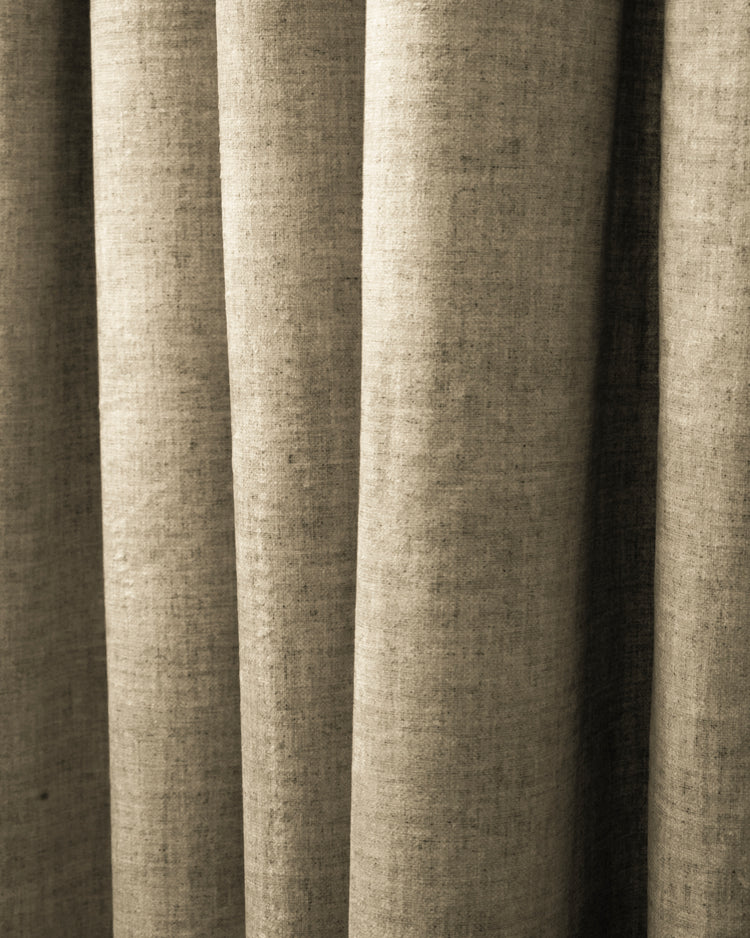 Detailed natural beige custom heavyweight drapery, highlighting the linen-patterned velvet fabric's rich texture and elegant folds.