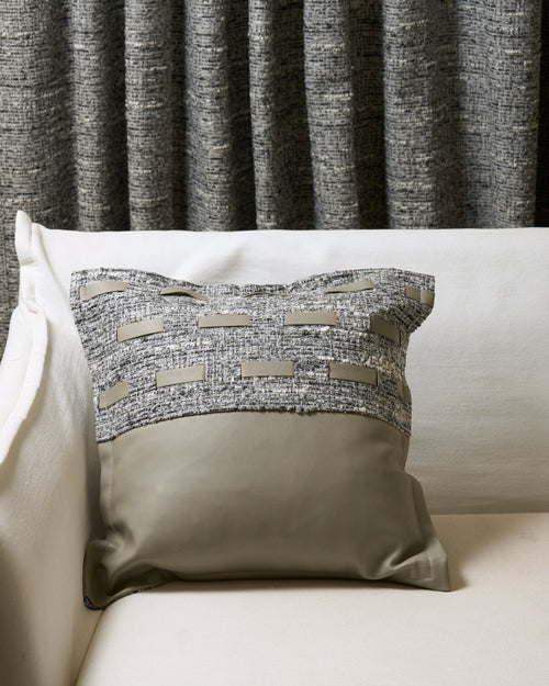 Juliette textured throw pillowcase with grey fabric & faux leather accents, taupe faux leather base, on sofa with matching custom drapery.