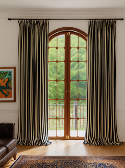 Full-length Liam striped linen blend custom curtains with black & cream stripes framing an arched door for sophisticated home decor.