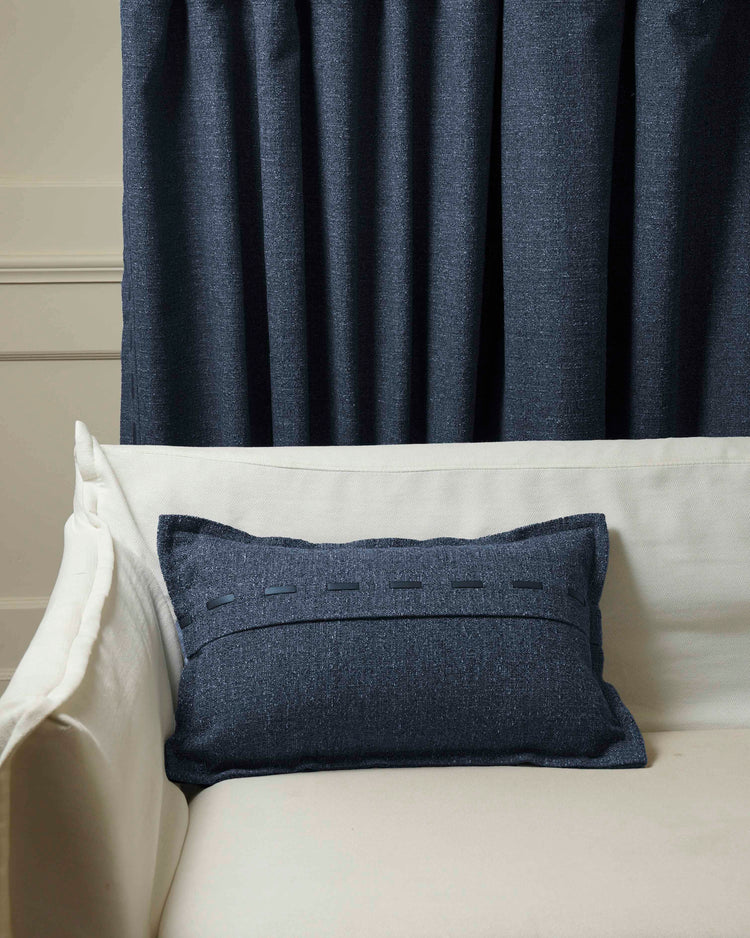 Sophisticated navy Luna Linen Blend lumbar pillowcase with faux leather lacing on a cream sofa, complementing custom drapery.