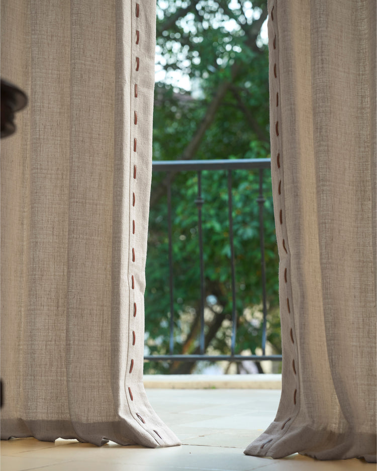Luna linen blend custom curtains with textured fabric and elegant trim, slightly parted to reveal a balcony and lush greenery