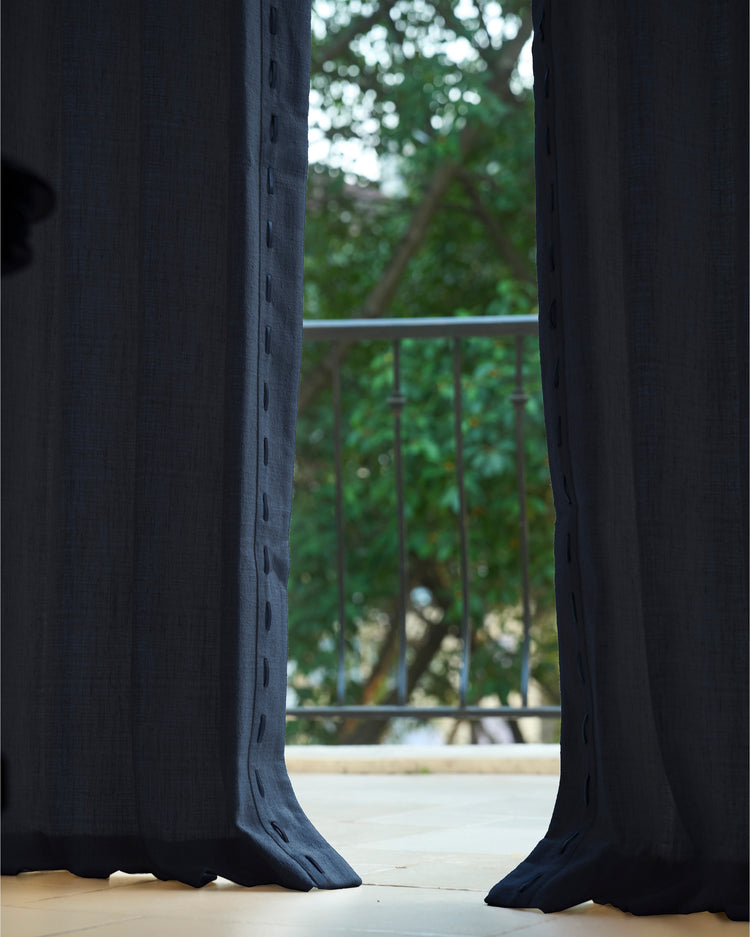 Dark blue Luna Linen Blend custom curtains with stitched trim open to a balcony view, highlighting textured fabric for home decor.