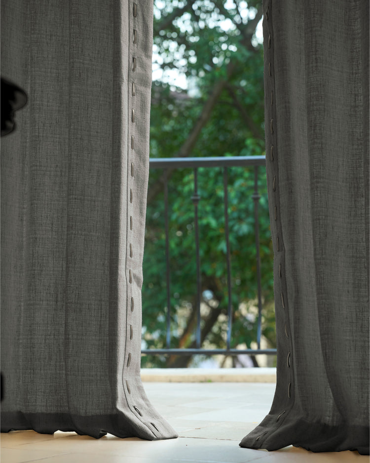 Luna textured linen blend custom drapery in charcoal grey with unique button-style trim, offering privacy for a balcony door.
