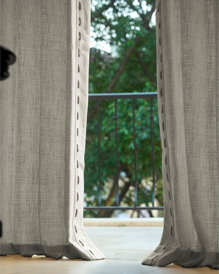 Luna Linen Blend Custom Curtains, textured fabric, with unique loop trim, partially open, showing a balcony and lush green trees.