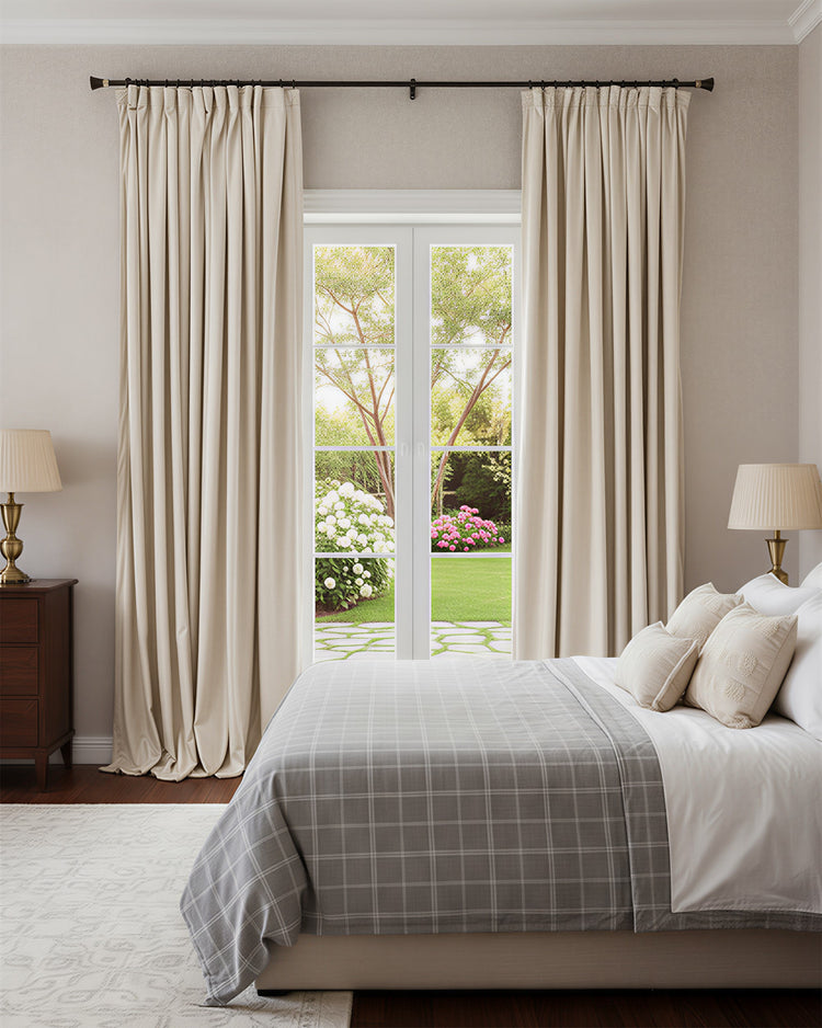 Elegant pleated beige blackout velvet custom curtains in a cozy bedroom, featuring heavy fabric, thermal, and soundproof design.
