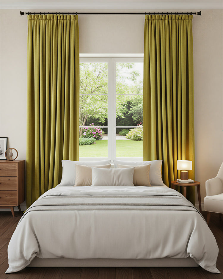 Chartreuse green heavyweight velvet custom blackout drapery with tailored pleats in a serene bedroom window setting.