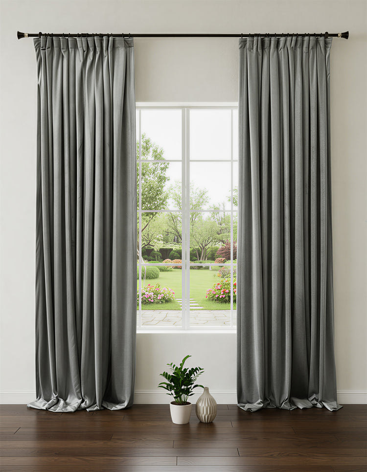 Moonlit custom heavyweight grey velvet 100% blackout curtains, elegantly pleated & pooling, framing a garden view window.
