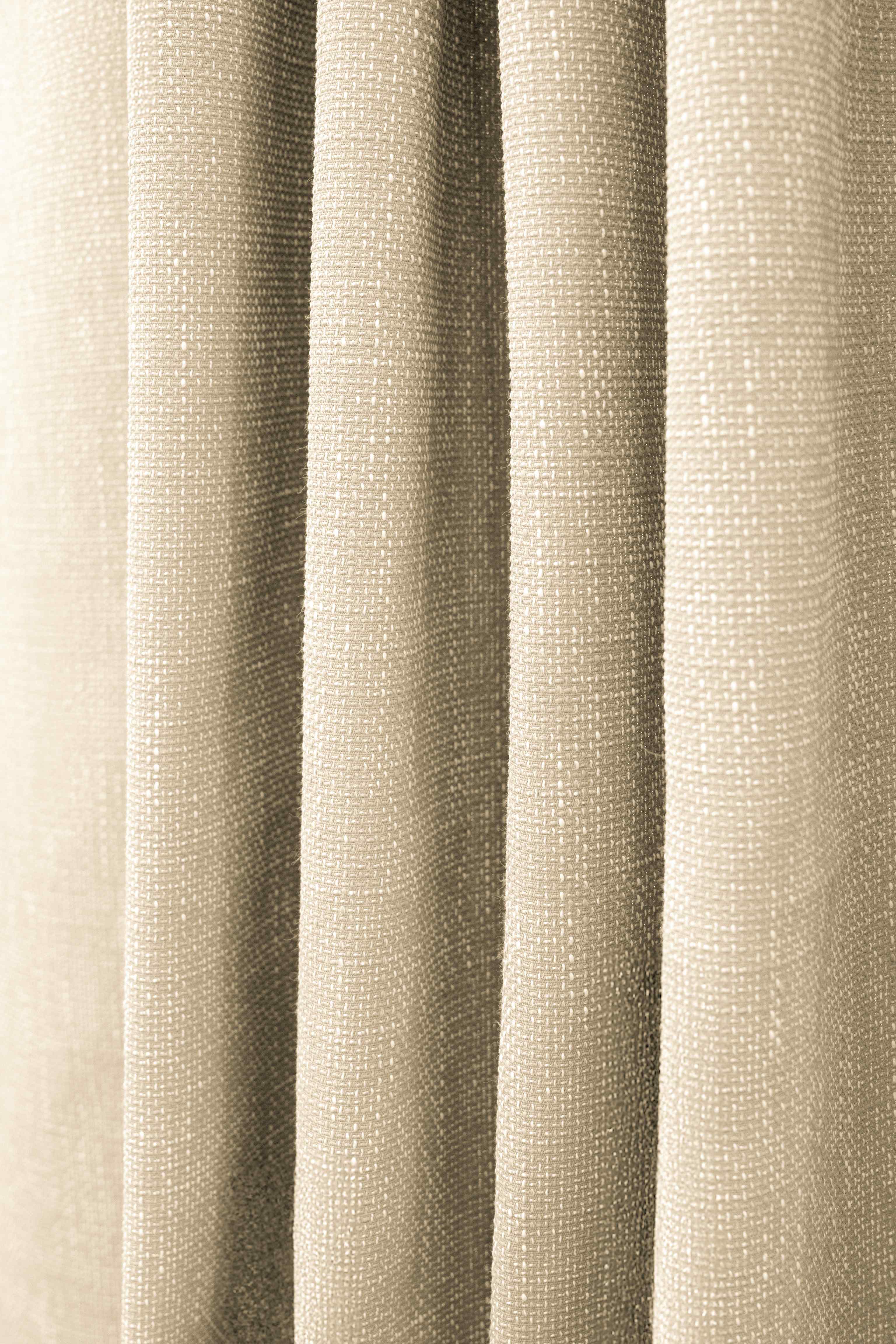 Detail of Munich custom outdoor curtain, highlighting its waterproof, woven textured fabric with a subtle pattern in beige.