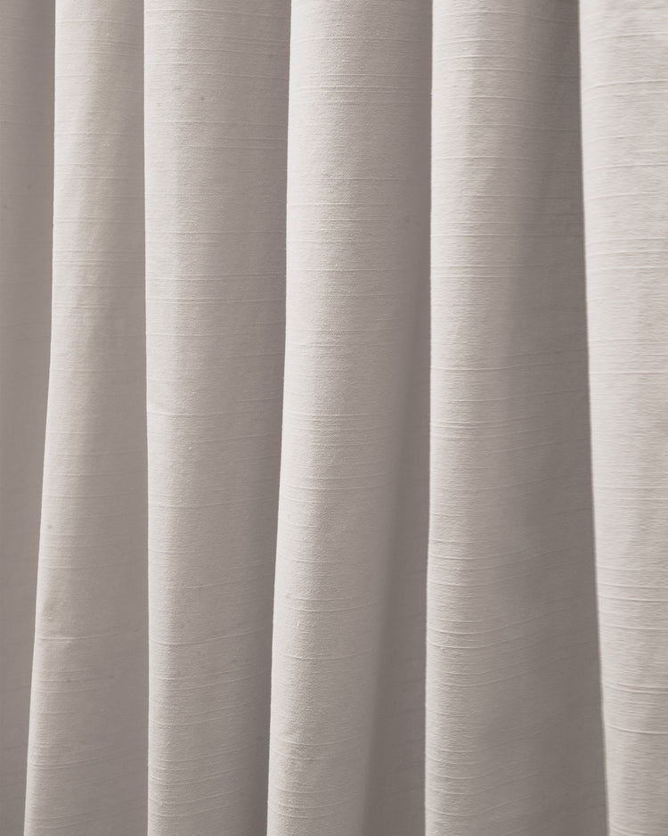 Close-up of lightweight Nara Linen Cotton Blend drapery fabric in a natural light color, showing its subtle texture and elegant folds.