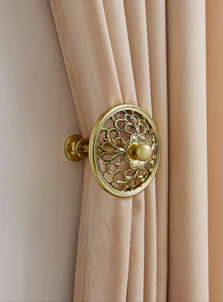 Decorative gold curtain tieback on a beige curtain