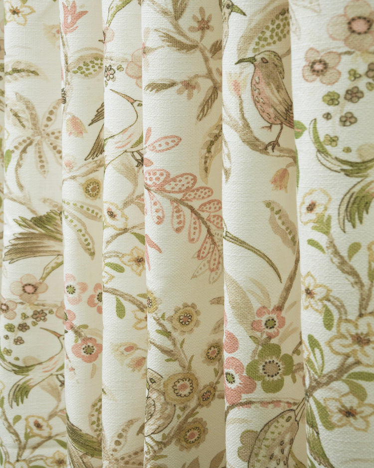 Pleated custom linen blend curtain with a delicate floral and bird pattern in soft pink, olive green, and beige.