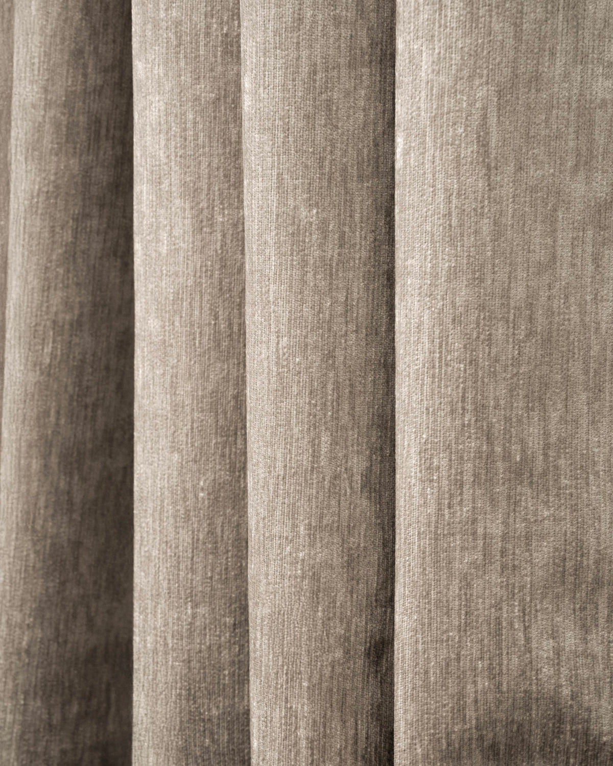 Close-up of Quinn 100% Blackout OEKO Heavyweight Velvet custom curtain fabric, showcasing plush texture and soft, vertical folds in taupe.