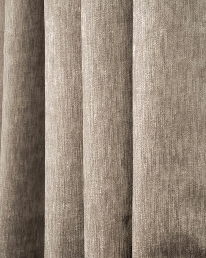 Close-up of Quinn 100% Blackout OEKO Heavyweight Velvet custom curtain fabric, showcasing plush texture and soft, vertical folds in taupe.