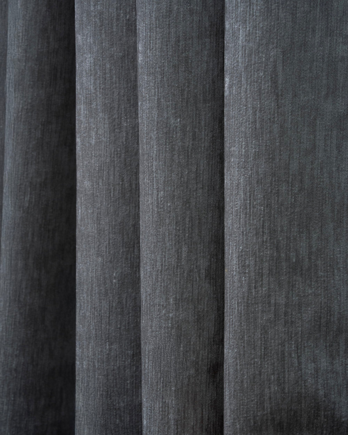 Textured close-up of Quinn heavyweight charcoal velvet custom blackout curtain, showcasing the luxurious pleated fabric.