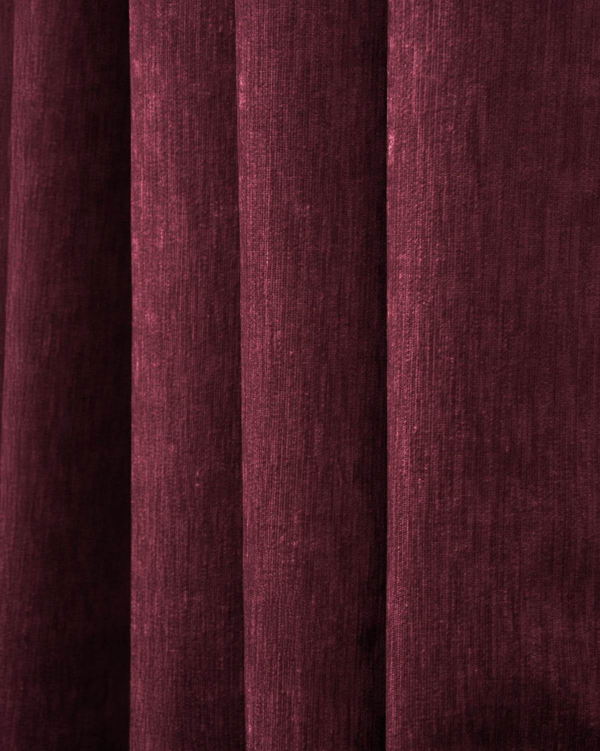 Close-up of deep maroon heavyweight velvet custom blackout curtain, showing rich texture and elegant pleats for luxurious window treatment.