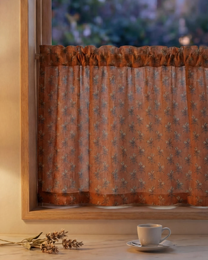 Burnt orange Rhythm Floral Patterned Custom Cafe Curtain with a ruffled rod pocket on a rustic wooden window frame.