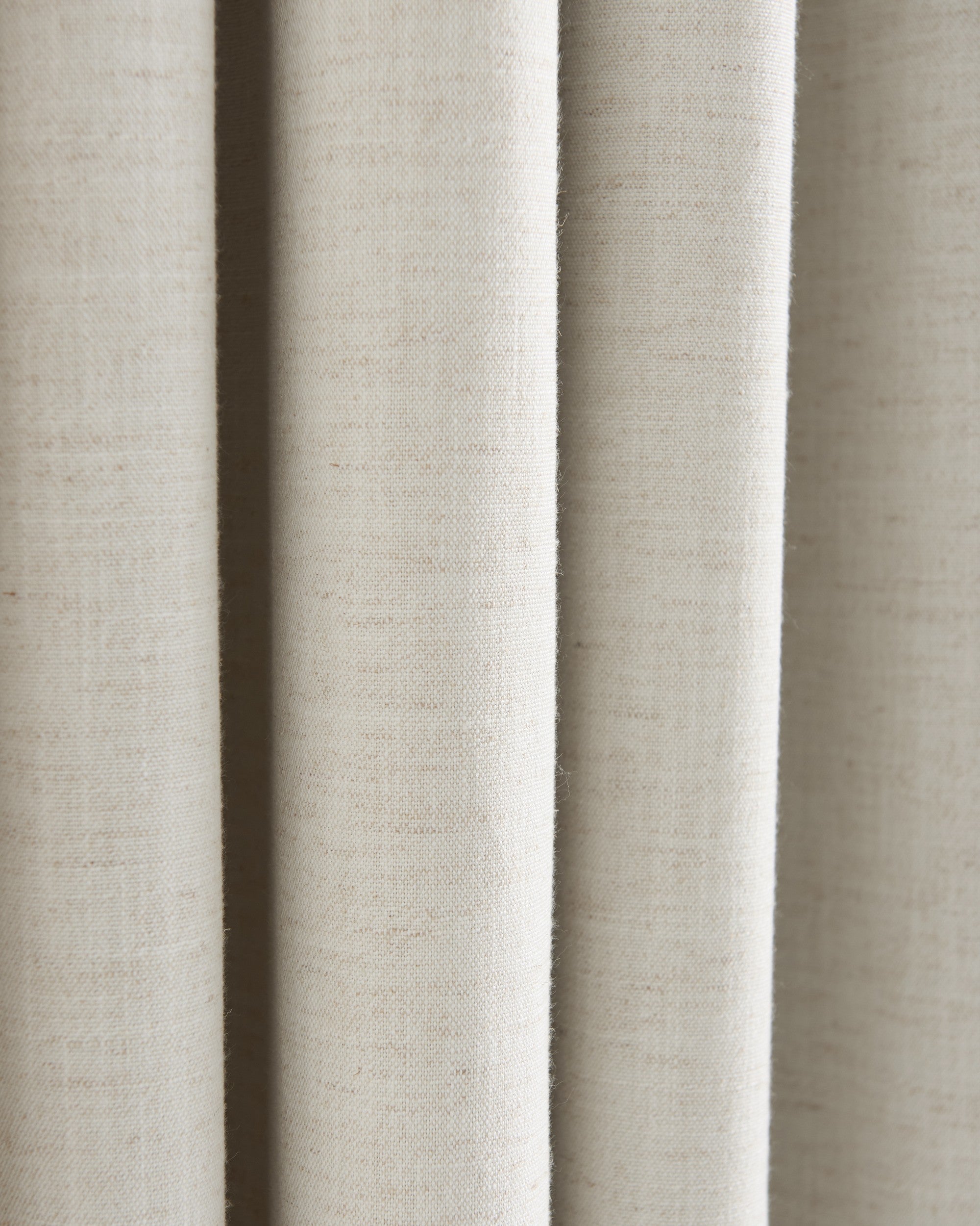 Detailed view of Sally Linen Blend fabric swatch in light beige, highlighting its natural slub texture and soft drapery folds.