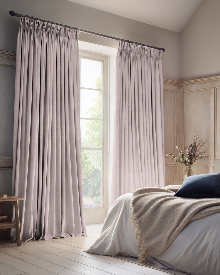 Muted rose linen blend custom blackout curtains with a tailored pinch pleat header, providing elegant light control in a chic bedroom.