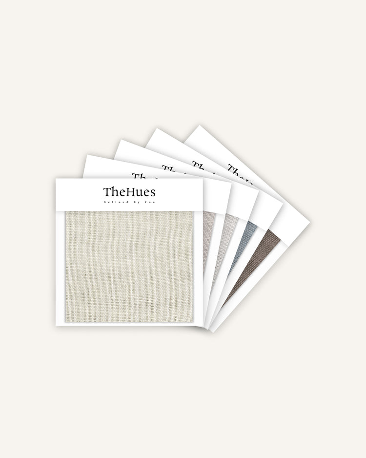 TheHues Thistle sheer fabric swatches fanned out, displaying light natural woven texture and various color samples for custom drapery.