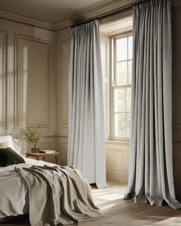 Voy 100% blackout linen look custom drapery, light grey pinch pleat curtains in a luxurious bedroom for light control.