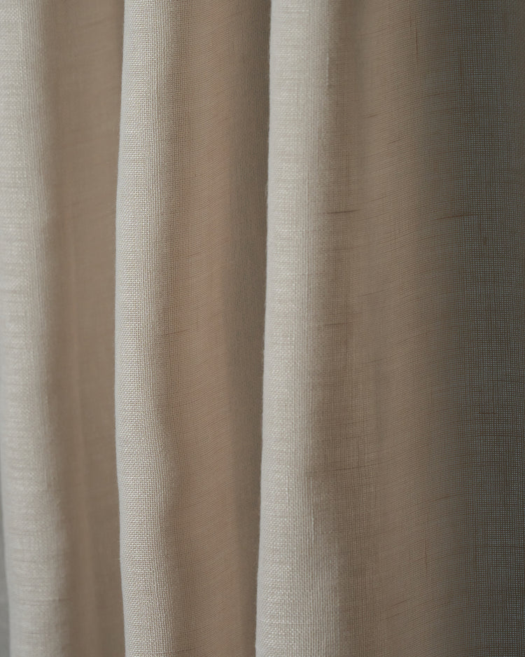 Light neutral yarn linen look sheer fabric swatch draped in soft folds, highlighting its delicate texture for custom window treatments.