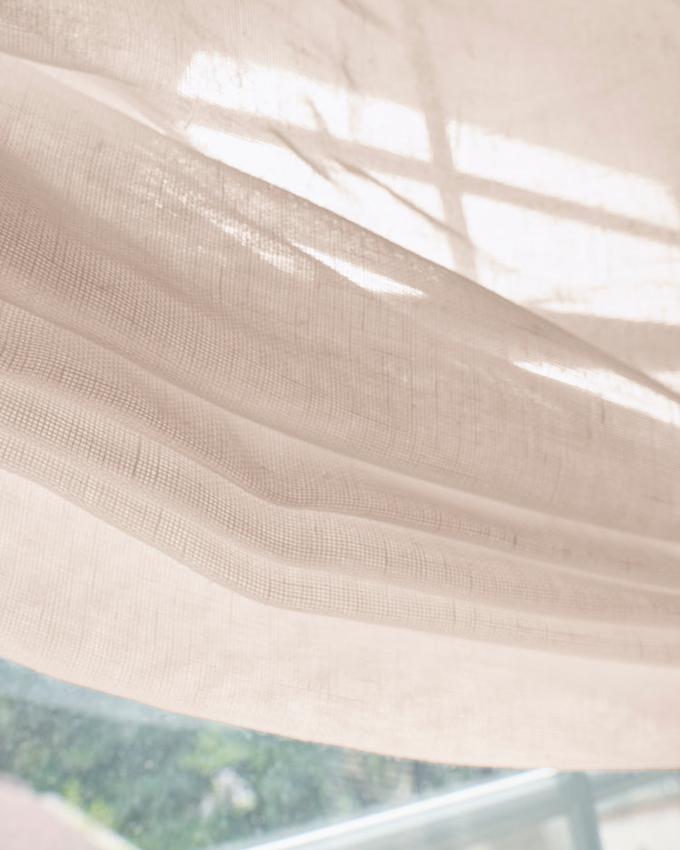 Close-up of a custom Yarn Sheer Relaxed Roman Shade, with sunlight highlighting its textured weave and translucent light-filtering quality.