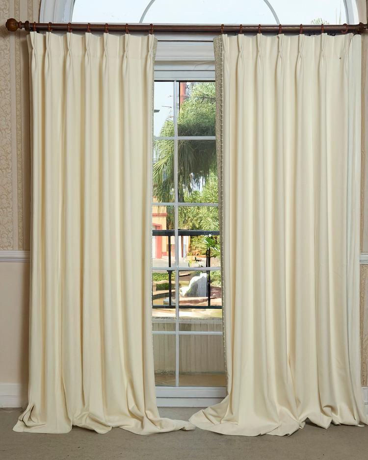 Zane textured cream custom drapery with elegant pinch pleat header and delicate yarn-stitched trim, for high-end window treatments.