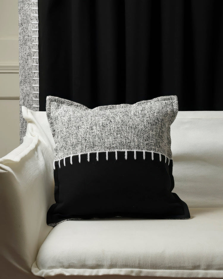 Zane wool blend black & grey yarn stitched throw pillowcase on white sofa; custom blackout curtain with textured trim.