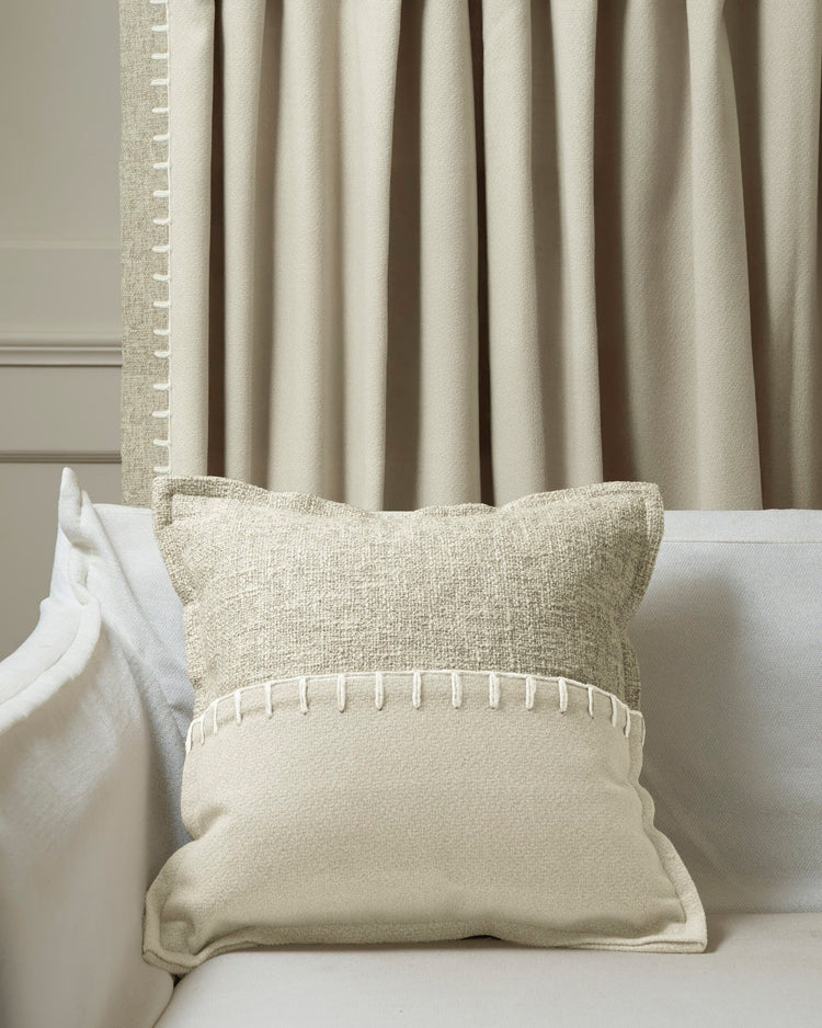 Tactile Zane wool blend throw pillowcase on sofa, with bold yarn-stitch trim & matching custom drapery for sophisticated home decor.