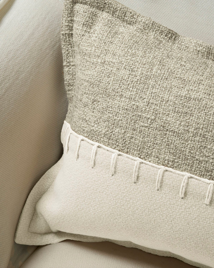 Close-up of Zane wool blend throw pillowcase with prominent yarn-stitched detail dividing textured gray and smoother cream fabrics.