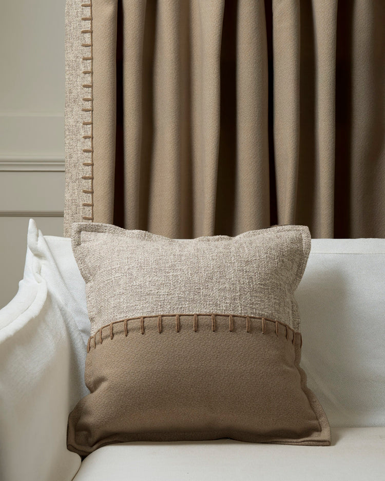 Two-tone Zane Wool Blend Throw Pillowcase with horizontal yarn stitching, complementing a beige custom drapery panel.