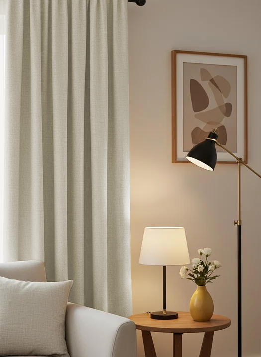 Zoe Linen Look custom drapery in natural beige with soft, elegant pleats, complementing a modern living room interior.