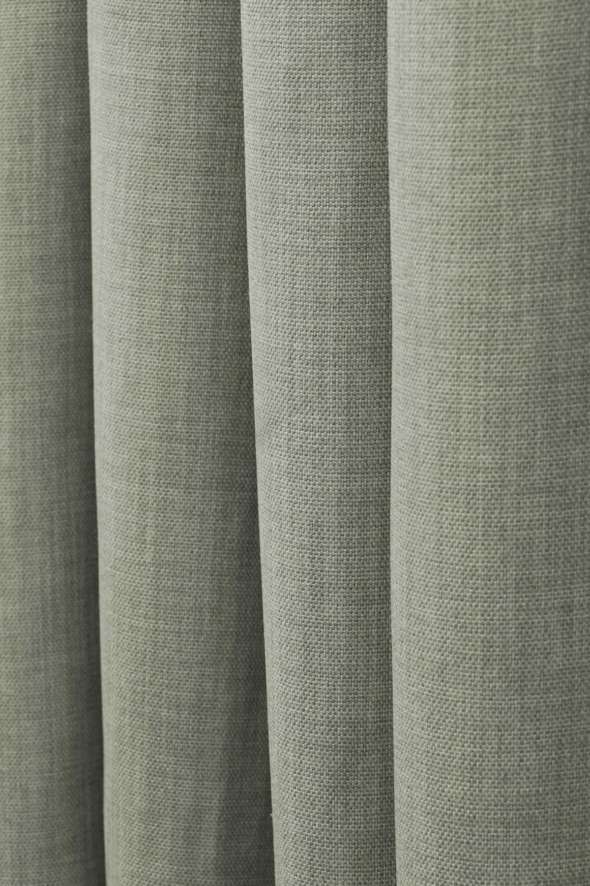 Close-up of Zoe linen-look soft custom curtain fabric in sage green, highlighting its natural weave and soft drape.
