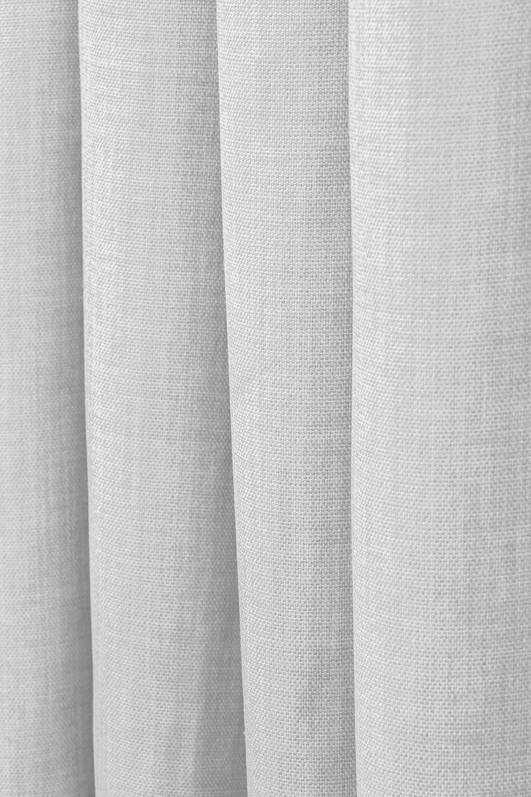 Close-up of Zoe Linen Look Soft Custom Drapery fabric, highlighting its light neutral woven texture and elegant folds.