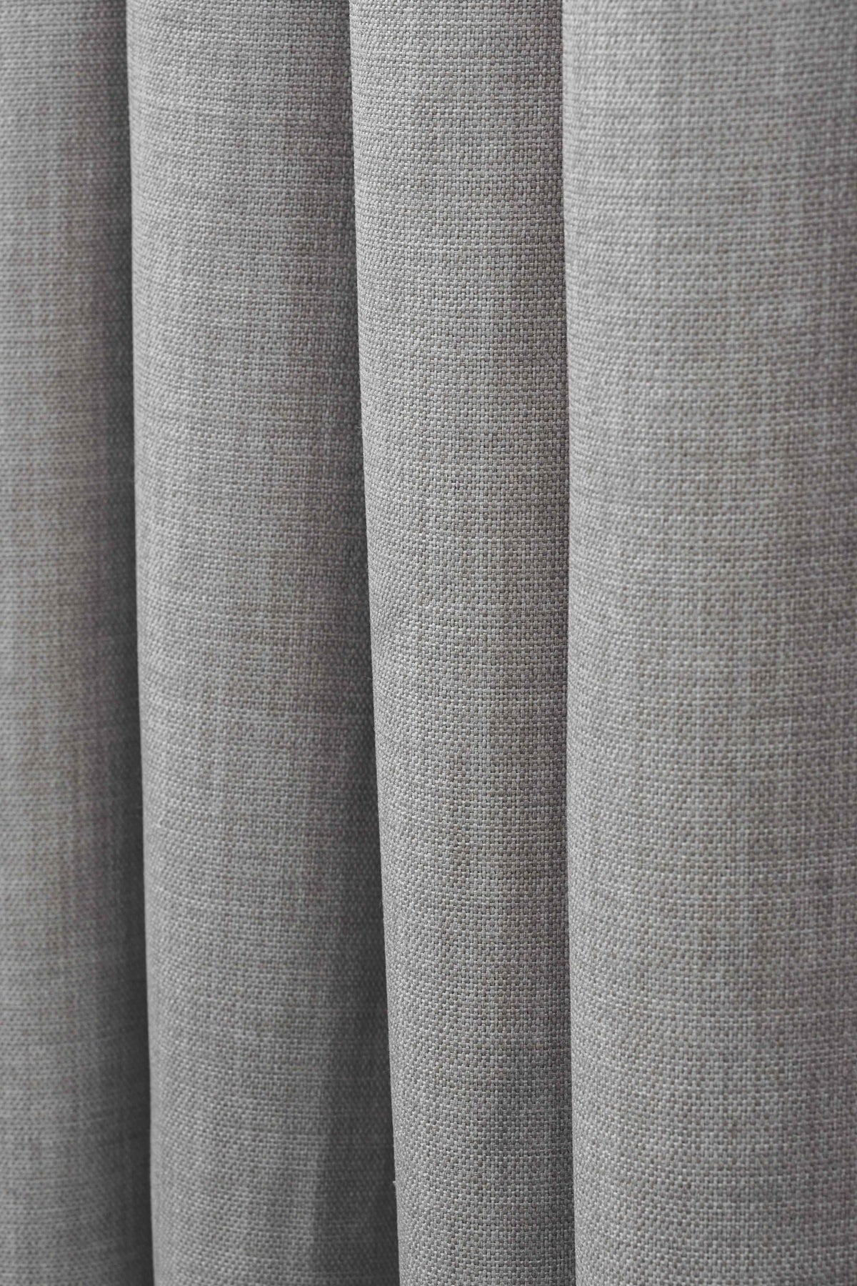 Close-up of Zoe custom drapery fabric, revealing soft grey linen-look texture and gentle folds for window treatments.