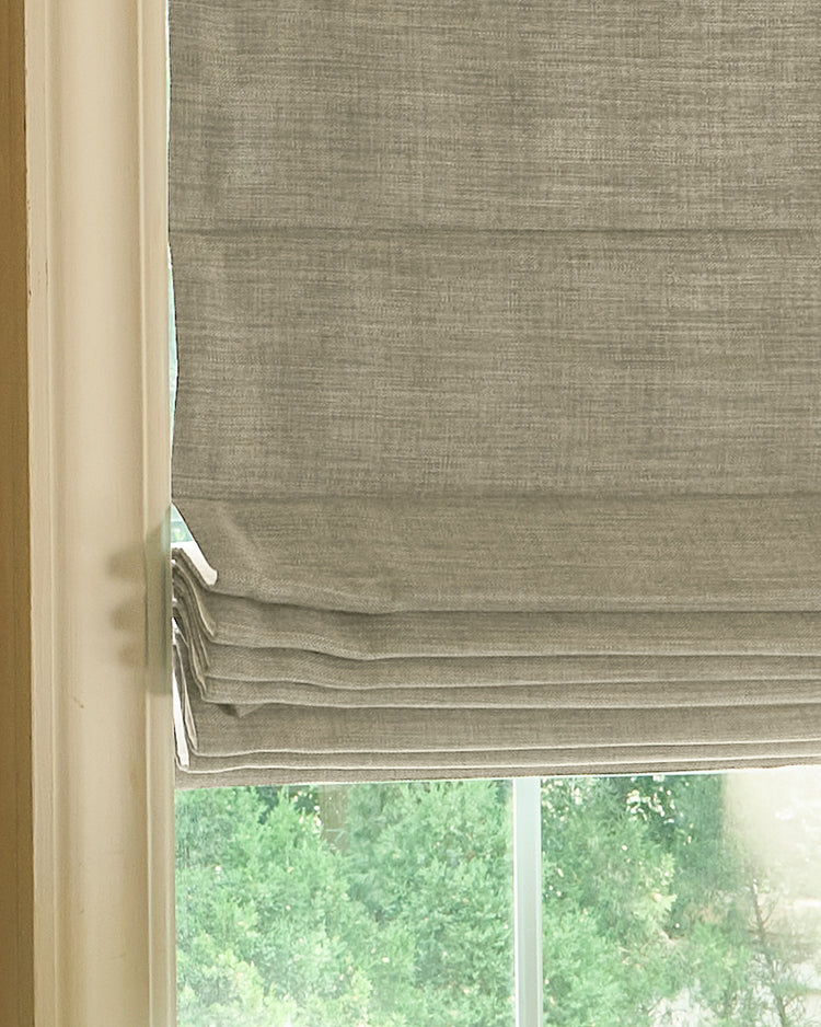 Custom Zoe Plain Fold Roman shade in a textured, light taupe linen-look fabric, enhancing home decor with elegant light control.