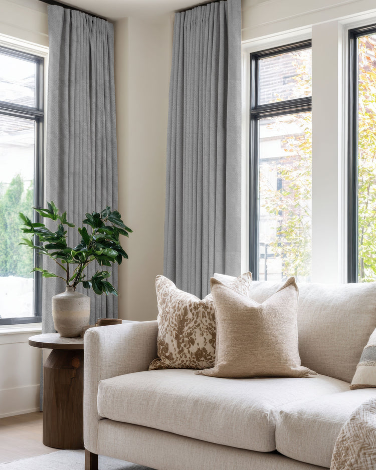 Zoe light grey custom blackout linen look curtains installed on modern living room windows, offering light control & privacy.